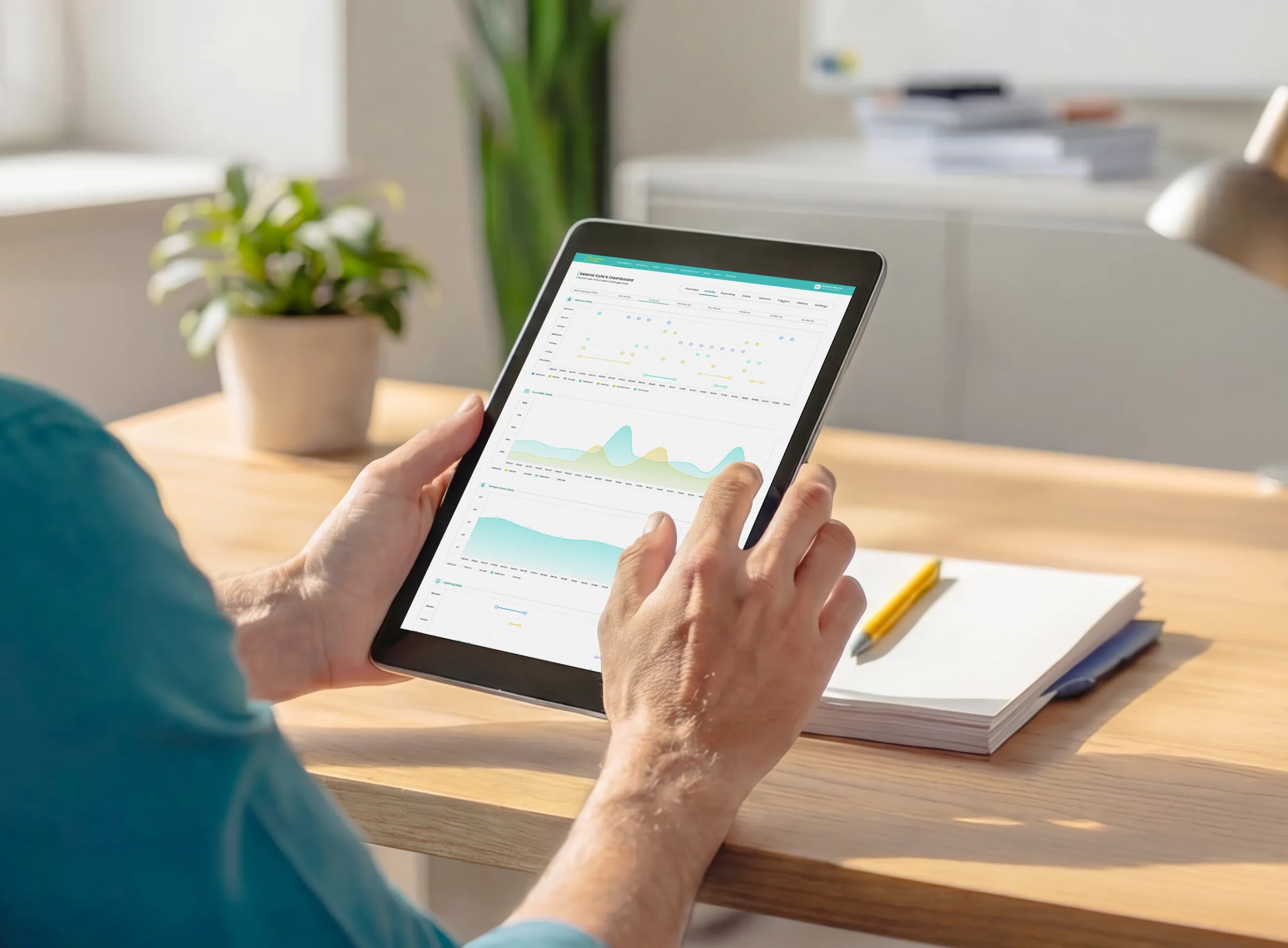 Person using the Canary Care Portal on a tablet to check real-time activity insights based on an individual’s routine at home.